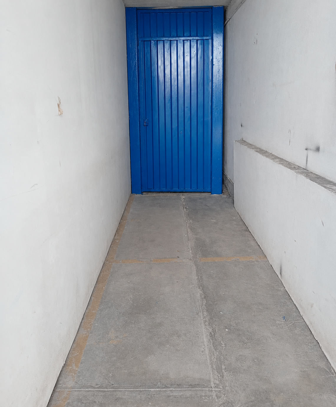 Puerta metálica azul instalada en pasillo interior del Proyecto Elant